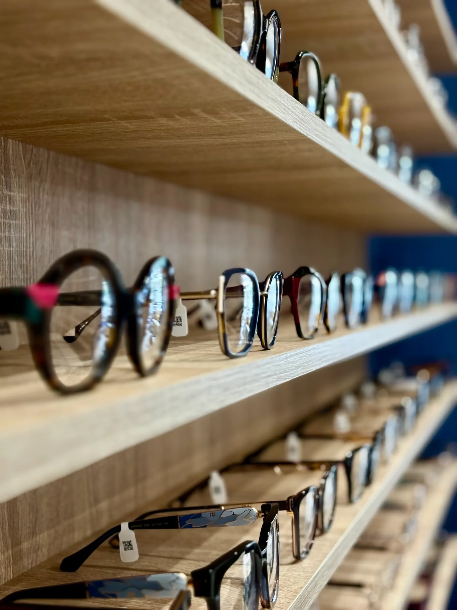 Różnorodne okulary na półkach.